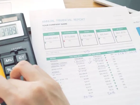 a hand holding a calculator and a paper with numbers eine Hand mit einem Taschenrechner und einem Zettel mit Zahlen