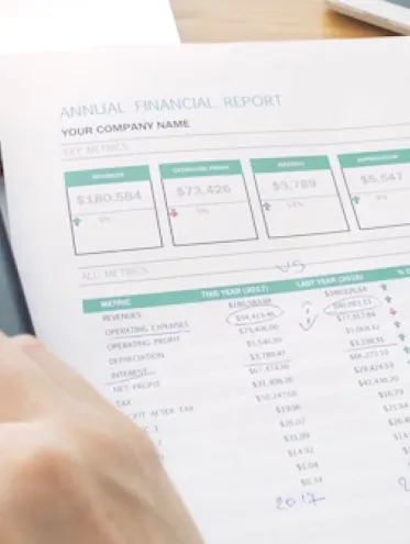 eine Hand mit einem Taschenrechner und einem Zettel mit Zahlen