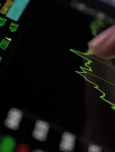 a finger pointing at a graph on a screen