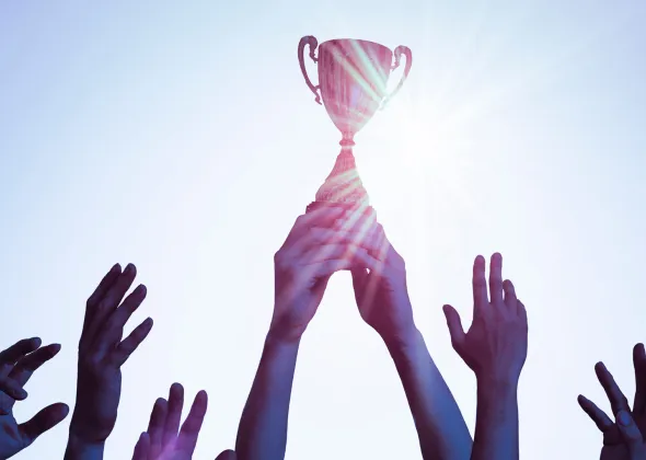 Eine Gruppe von Händen, die nach einer Trophäe greifen