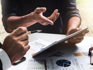 Eine Nahaufnahme von Händen, die einen Stift und ein Tablet halten