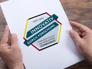 hands holding a paper with a logo