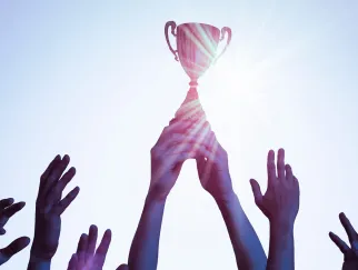 Eine Gruppe von Händen, die nach einer Trophäe greifen