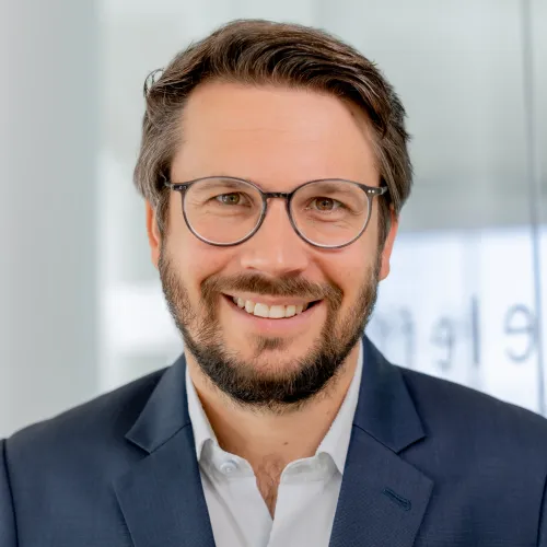 a man wearing glasses and a suit