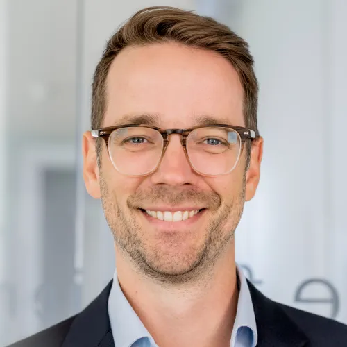 a man wearing glasses smiling